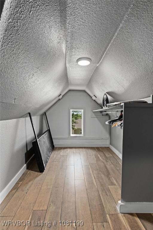 2101 Birnie Ave, Fort Smith, AR 72904 - bonus room featuring a textured ceiling, hardwood / wood-style flooring, baseboards, and vaulted ceiling