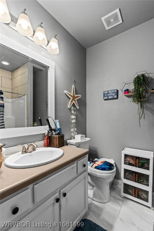 2101 Birnie Ave, Fort Smith, AR 72904 - full bathroom with vanity, marble finish floors, toilet, a shower with shower curtain, and a textured wall