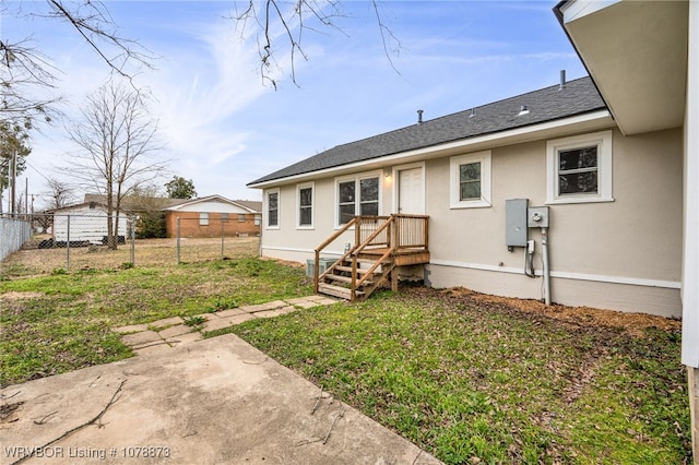 back of property with a lawn and a patio