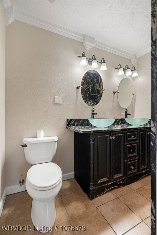 bathroom with crown molding, vanity, toilet, and a textured ceiling