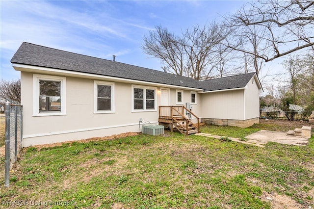 rear view of property with a yard and central air condition unit