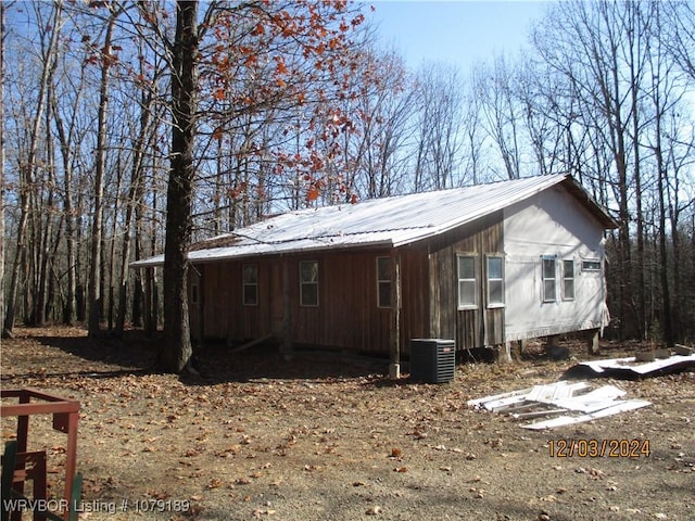 view of property exterior with metal roof and central AC unit