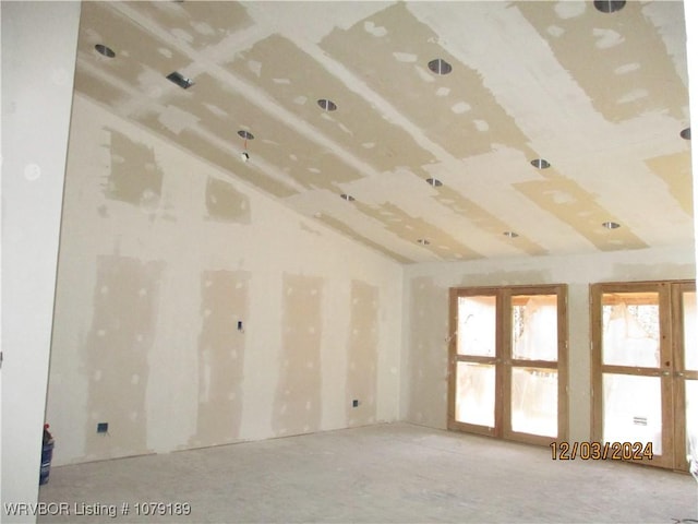 empty room featuring vaulted ceiling and french doors