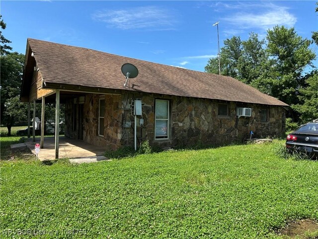 3329 Furry Way, Van Buren, AR 72956 - rear view of house featuring a patio area, stone siding, a wall mounted air conditioner, a lawn, and roof with shingles