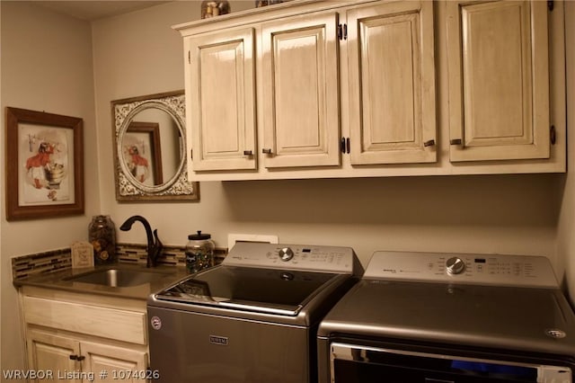 clothes washing area featuring cabinets, washer and clothes dryer, and sink