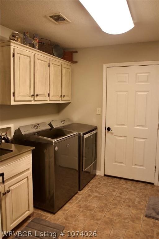 laundry area with cabinets and washer and clothes dryer