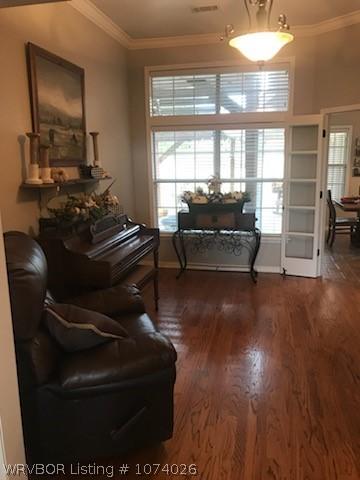 living area featuring dark hardwood / wood-style flooring and ornamental molding