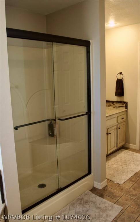 bathroom featuring vanity and an enclosed shower