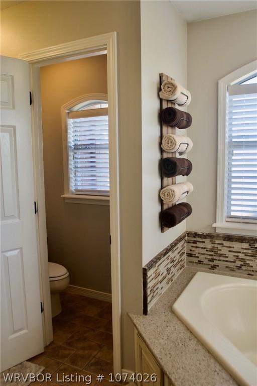 bathroom featuring toilet and a bath