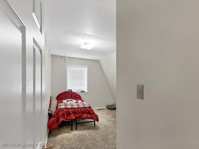 carpeted bedroom featuring lofted ceiling