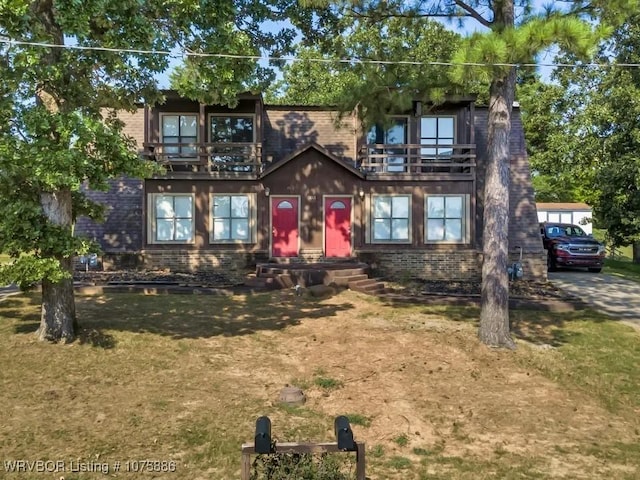 view of front of home with a balcony and a front yard