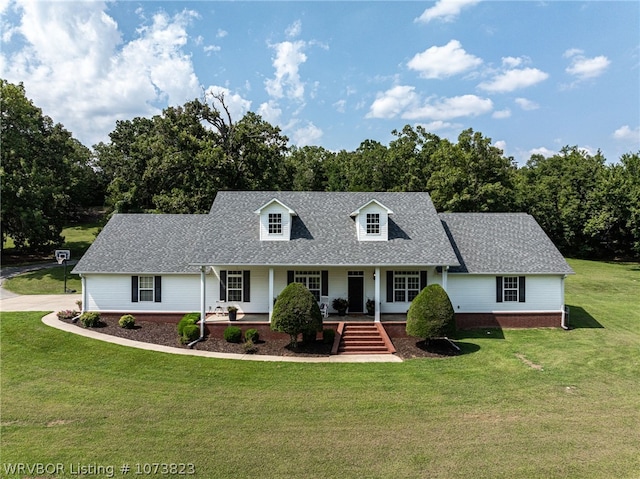 new england style home featuring covered porch and a front yard