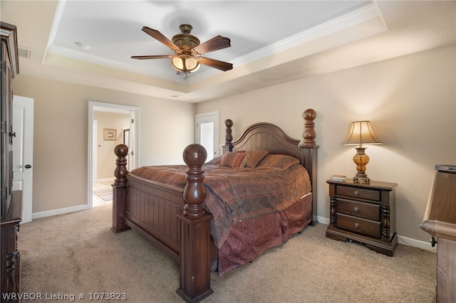 bedroom featuring a raised ceiling, ceiling fan, light carpet, and ornamental molding