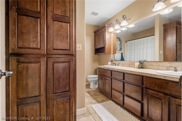 bathroom featuring tile patterned floors, vanity, and toilet