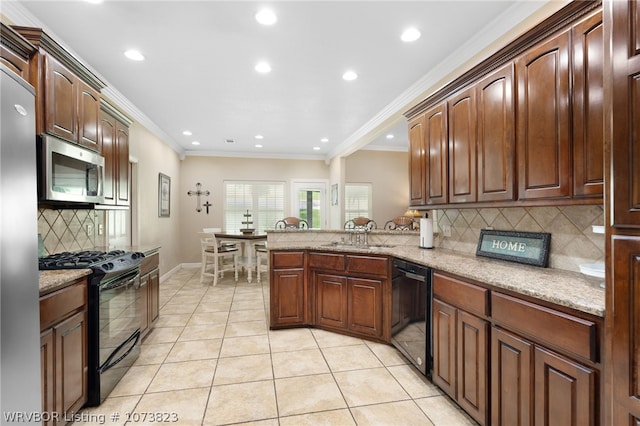 kitchen with decorative backsplash, sink, black appliances, and light stone counters