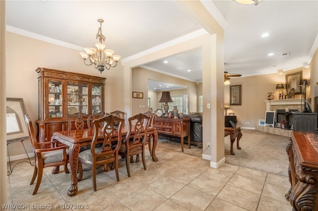 tiled dining space featuring ceiling fan with notable chandelier and ornamental molding