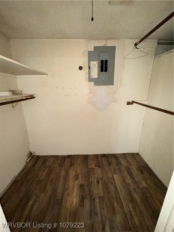 walk in closet with dark wood-type flooring and electric panel