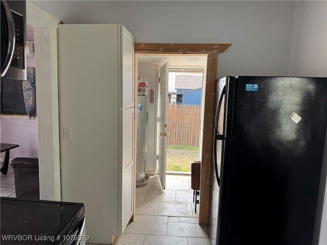 kitchen with white cabinets, plenty of natural light, and freestanding refrigerator