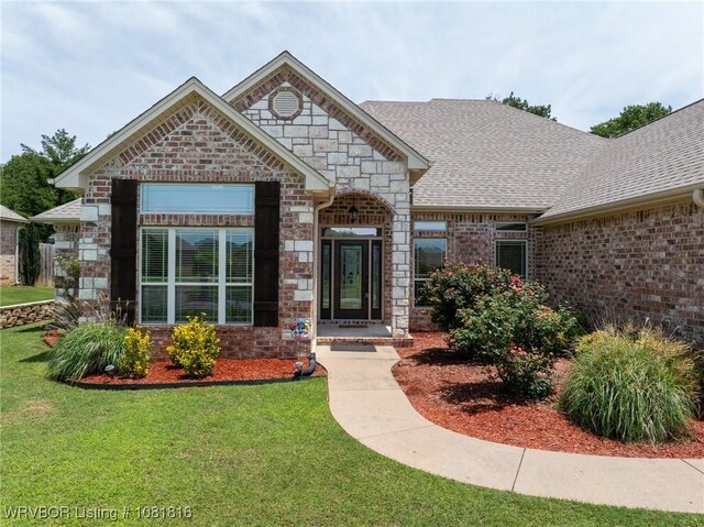 12905 Limestone Dr, Fort Smith, AR 72916 - view of front of home featuring a front yard, a shingled roof, and stone siding