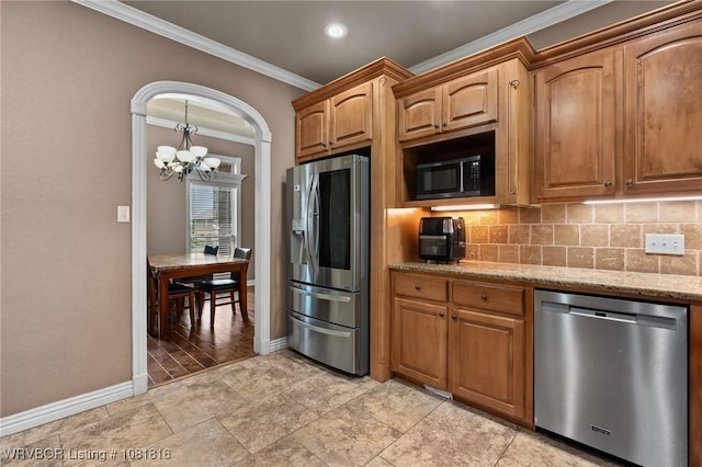12905 Limestone Dr, Fort Smith, AR 72916 - kitchen with appliances with stainless steel finishes, crown molding, a chandelier, light stone counters, and tasteful backsplash