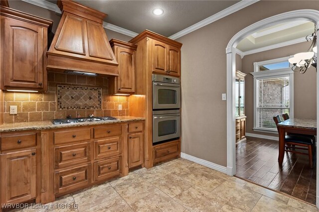12905 Limestone Dr, Fort Smith, AR 72916 - kitchen featuring stainless steel appliances, custom range hood, ornamental molding, light stone countertops, and tasteful backsplash