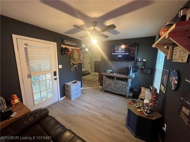 living room featuring ceiling fan and light wood-type flooring