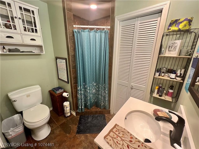 bathroom featuring a shower with shower curtain, vanity, and toilet