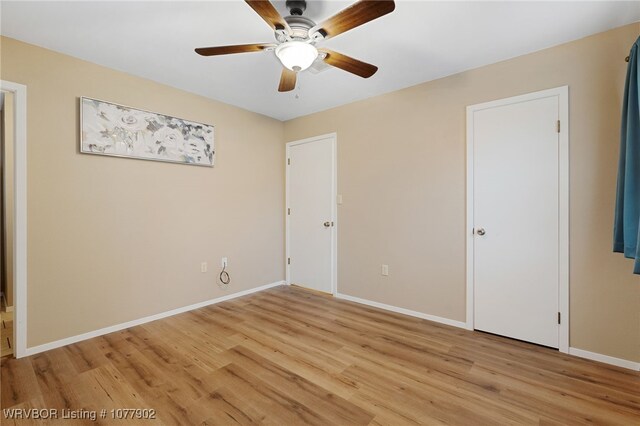 empty room with ceiling fan and light hardwood / wood-style floors