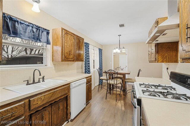 kitchen with sink, ventilation hood, a chandelier, decorative light fixtures, and white appliances