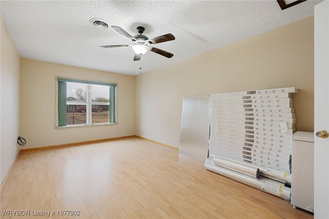 interior space with ceiling fan, a textured ceiling, and light wood-type flooring