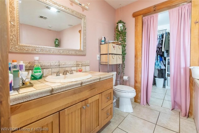 bathroom featuring toilet, visible vents, vanity, and tile patterned floors