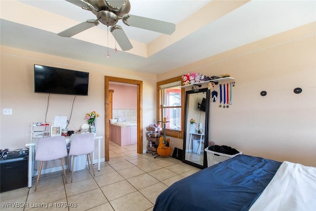 bedroom with light tile patterned floors and a tray ceiling