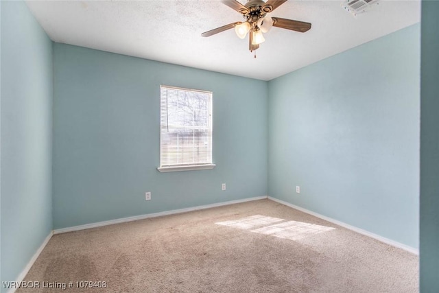 spare room featuring a ceiling fan, carpet, visible vents, and baseboards