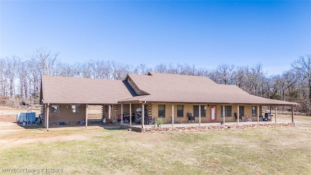 view of front of property featuring a shingled roof, a patio, log exterior, and a front lawn