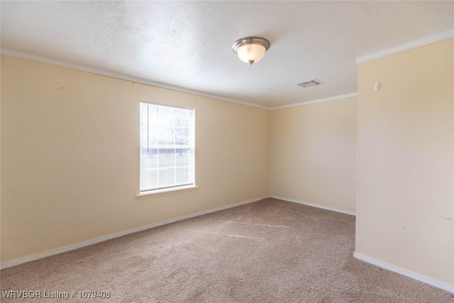 carpeted spare room featuring ornamental molding, visible vents, and baseboards