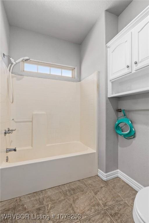 full bathroom with baseboards, bathing tub / shower combination, toilet, and tile patterned floors