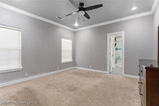 spare room with a ceiling fan, visible vents, baseboards, ornamental molding, and carpet