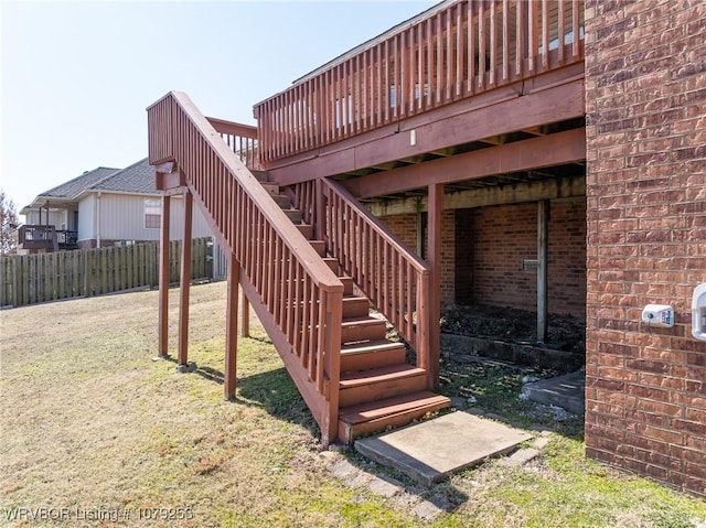 exterior space featuring fence, a lawn, and stairs