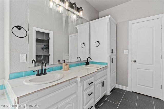 full bath featuring double vanity, tile patterned flooring, and a sink