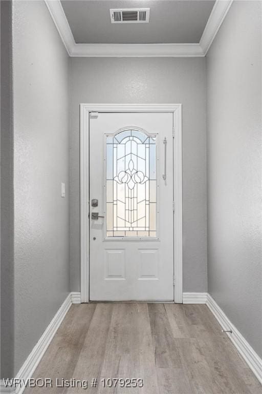 entrance foyer with visible vents, crown molding, baseboards, and wood finished floors