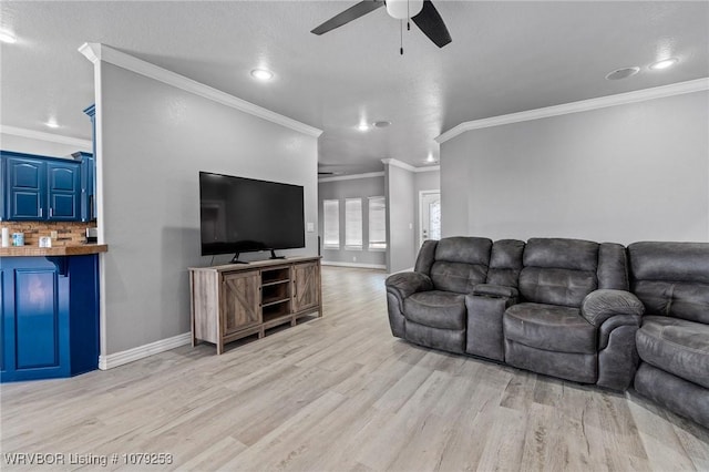 living room with light wood-type flooring, crown molding, baseboards, and a ceiling fan