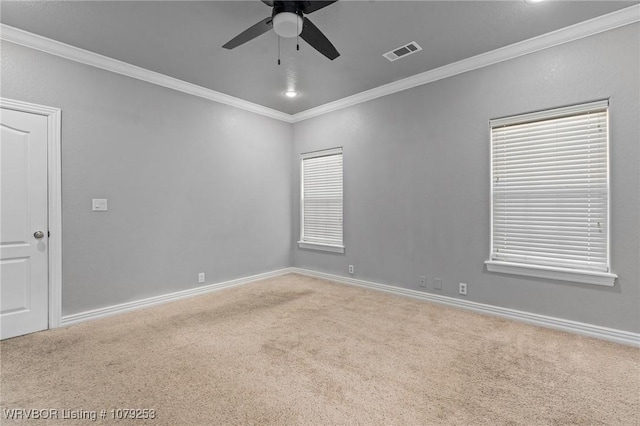 unfurnished room featuring baseboards, carpet, visible vents, and crown molding