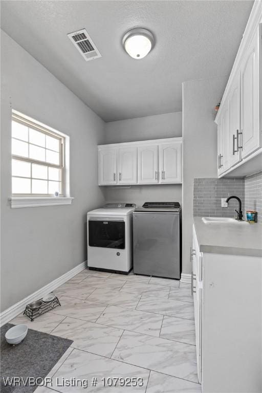 laundry area with a sink, visible vents, marble finish floor, cabinet space, and washing machine and clothes dryer