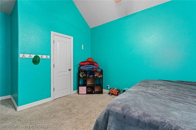 carpeted bedroom featuring lofted ceiling and baseboards