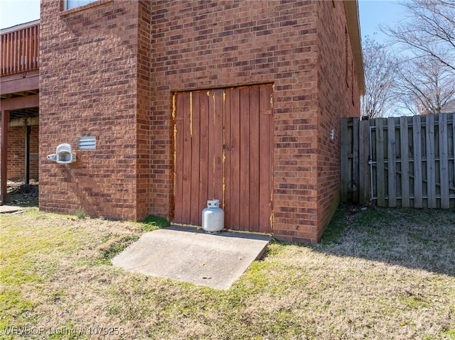 view of home's exterior with a yard, fence, and brick siding