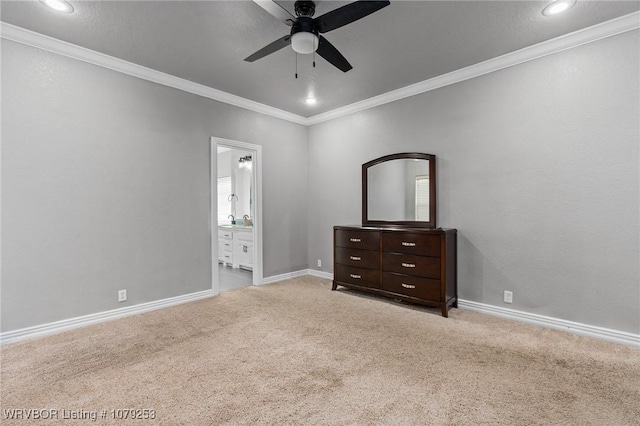 unfurnished bedroom featuring baseboards, carpet floors, ensuite bathroom, and crown molding