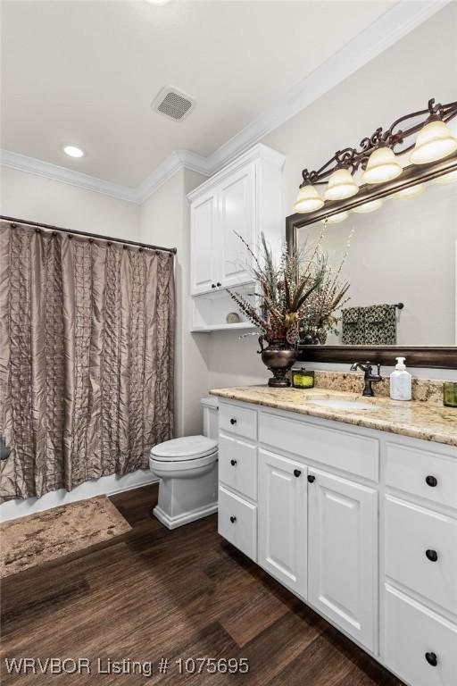 bathroom featuring toilet, vanity, ornamental molding, and hardwood / wood-style flooring