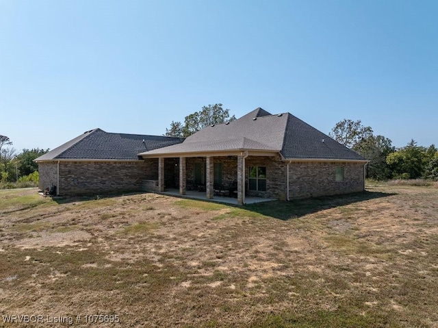 rear view of house with a lawn and a patio area