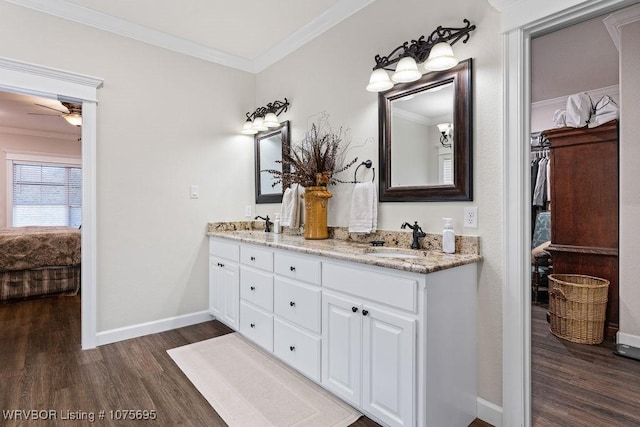 bathroom with crown molding, vanity, wood-type flooring, and ceiling fan