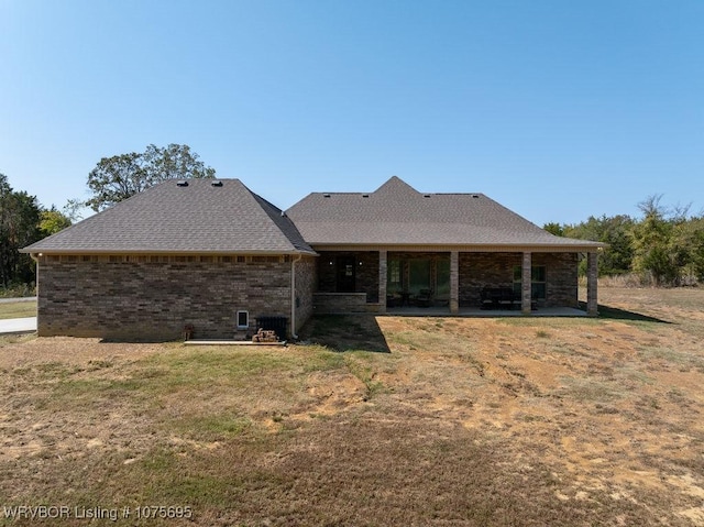 rear view of property featuring a lawn and a patio area